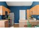 A spacious kitchen has stainless appliances, wood cabinets, tile countertops, and overlooks the dining area at 22580 E Ontario Dr # 204, Aurora, CO 80016
