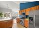 Bright kitchen with stainless steel appliances, tile countertops, and an open floor plan overlooking the living area at 22580 E Ontario Dr # 204, Aurora, CO 80016