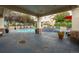 Community pool area with a jacuzzi, lounge chairs, tables, and mature trees around the area at 22580 E Ontario Dr # 204, Aurora, CO 80016