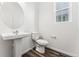 Well-lit powder room with modern fixtures, pedestal sink, and wood-look flooring at 3295 N Coolidge Way, Aurora, CO 80019