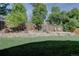 Backyard featuring a stone terrace with barrel planters, fire pit, fence and a grass lawn at 8043 S Zephyr St, Littleton, CO 80128