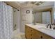Bathroom featuring double sinks, vanity, framed mirror, tub and shower with modern fixtures and great lighting at 8043 S Zephyr St, Littleton, CO 80128
