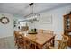 Formal dining room featuring a large wooden table, modern chandelier, and view into the bright kitchen at 8043 S Zephyr St, Littleton, CO 80128