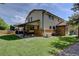 Exterior of two story home features a well maintained lawn with a covered patio and swing for outdoor relaxation at 8043 S Zephyr St, Littleton, CO 80128