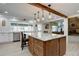 Lovely kitchen featuring a granite island with hanging lights and an open doorway to the cozy living room at 8043 S Zephyr St, Littleton, CO 80128
