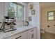 Well-lit kitchen nook with white cabinets, marble countertops, and modern stainless steel appliances at 8043 S Zephyr St, Littleton, CO 80128