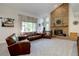 Spacious living room featuring a brick fireplace, large windows, and comfortable leather furniture at 8043 S Zephyr St, Littleton, CO 80128