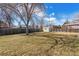 Spacious backyard with mature trees, a wood fence, and a storage shed at 1231 Missouri Ave, Longmont, CO 80501