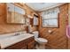 A bathroom featuring wood-paneled walls and classic fixtures at 1231 Missouri Ave, Longmont, CO 80501