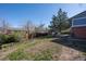 Spacious backyard with grass, wood fence, a deck, and mature trees at 16933 E Bethany Pl, Aurora, CO 80013