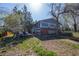 Large backyard with a deck, blue siding, brick accents, mature trees, and a fence at 16933 E Bethany Pl, Aurora, CO 80013