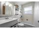 Cozy bathroom with a tub and shower, white vanity, decorative shelves, and vintage wallpaper at 16933 E Bethany Pl, Aurora, CO 80013