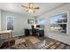 Bright home office with a ceiling fan, black desk, windows, and layered rugs at 16933 E Bethany Pl, Aurora, CO 80013