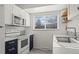 Updated kitchen with white cabinetry, dark blue base cabinets, stainless steel appliances, and stylish backsplash at 16933 E Bethany Pl, Aurora, CO 80013