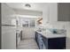 Modern kitchen with white cabinets, blue base cabinets, stainless steel appliances, and ample natural light at 16933 E Bethany Pl, Aurora, CO 80013