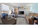 Comfortable living room with a large brick wall, hardwood floors, and comfortable seating arrangements at 16933 E Bethany Pl, Aurora, CO 80013