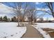 Paved walking path through a snow-covered park with mature trees and residential areas in the background at 16933 E Bethany Pl, Aurora, CO 80013