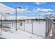 Fenced outdoor tennis court with full lighting, adjacent to a parking area at 16933 E Bethany Pl, Aurora, CO 80013