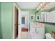 Bathroom with green walls, white vanity, and views to the hallway and bedrooms at 18200 E Asbury Pl, Aurora, CO 80013