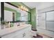 Bathroom with green walls, white vanity, large mirror, and shower tub combination at 18200 E Asbury Pl, Aurora, CO 80013