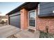 Close-up view of the red brick entry showcasing the charming front door and garage at 18200 E Asbury Pl, Aurora, CO 80013