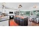 Open kitchen boasts an island, stainless appliances, white cabinets, and flows to living and dining area at 18200 E Asbury Pl, Aurora, CO 80013