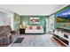 Cozy living room features green walls, stylish furniture, decor, and wood floors at 18200 E Asbury Pl, Aurora, CO 80013