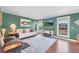 Bright living room with large windows, hardwood floors, green walls, and stylish furniture at 18200 E Asbury Pl, Aurora, CO 80013