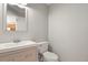 Bathroom with light wood vanity, modern sink and faucet, toilet, and large mirror creates a peaceful retreat at 4540 Crestone Peak St, Brighton, CO 80601