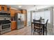 Kitchen features stainless steel appliances, wooden cabinets, and an adjacent dining area filled with natural light at 4540 Crestone Peak St, Brighton, CO 80601
