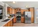 Modern kitchen featuring wood cabinets, stainless steel appliances, and quartz countertops at 4540 Crestone Peak St, Brighton, CO 80601