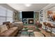 Modern living room with stone accent wall, fireplace, large TV, and unique furnishings at 4540 Crestone Peak St, Brighton, CO 80601