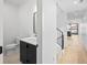 Clean half bathroom featuring black finishes, a modern mirror and a white sink with staircase view at 1258 Yates St, Denver, CO 80204