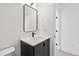 Stylish bathroom featuring a black vanity, modern mirror, and clean white walls at 1258 Yates St, Denver, CO 80204