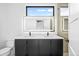 Modern bathroom featuring a double vanity, illuminated mirror, and glass-enclosed shower at 1258 Yates St, Denver, CO 80204