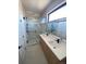 Modern bathroom featuring a glass shower, double vanity with modern fixtures, and a large mirror at 1258 Yates St, Denver, CO 80204