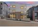 Modern home featuring a gray facade, black window frames, and brick accents under a dramatic sky at 1258 Yates St, Denver, CO 80204