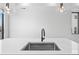 Close-up of a kitchen island featuring a stainless steel sink, black faucet, and modern pendant lights at 1258 Yates St, Denver, CO 80204