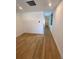 Bright living room with hardwood floors and ample natural light from windows in the connecting hall at 1258 Yates St, Denver, CO 80204