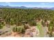 Breathtaking aerial view of a home nestled among lush trees and mountain scenery at 20425 Flint Ln, Morrison, CO 80465