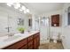 Bathroom featuring double sinks, shower, and wood cabinets at 20425 Flint Ln, Morrison, CO 80465