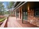 Spacious outdoor deck featuring stone accents and wooden trim overlooking scenic forest views at 20425 Flint Ln, Morrison, CO 80465