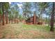 A rustic home with a wooden deck and a pergola, set amidst a tranquil, wooded landscape at 20425 Flint Ln, Morrison, CO 80465