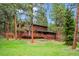 Charming two-story home with wooden deck nestled among lush trees and a well-maintained lawn at 20425 Flint Ln, Morrison, CO 80465