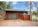 A single-car garage with an extra storage space. Wood siding and a green door at 20425 Flint Ln, Morrison, CO 80465