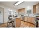Bright kitchen featuring natural wood cabinets, stainless steel appliances, and hardwood floors at 20425 Flint Ln, Morrison, CO 80465