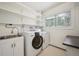 Laundry room with sink, folding counter, shelving and front-loading machines at 20425 Flint Ln, Morrison, CO 80465