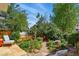 Landscaped backyard with stone pathway, lush plants, and outdoor seating at 8256 E 28Th Dr, Denver, CO 80238