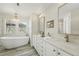 Luxurious bathroom with soaking tub, double vanity, and stylish lighting at 8256 E 28Th Dr, Denver, CO 80238