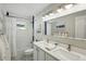 Well-lit bathroom with double vanity, framed mirror, subway tile shower, and patterned tile floor at 8256 E 28Th Dr, Denver, CO 80238